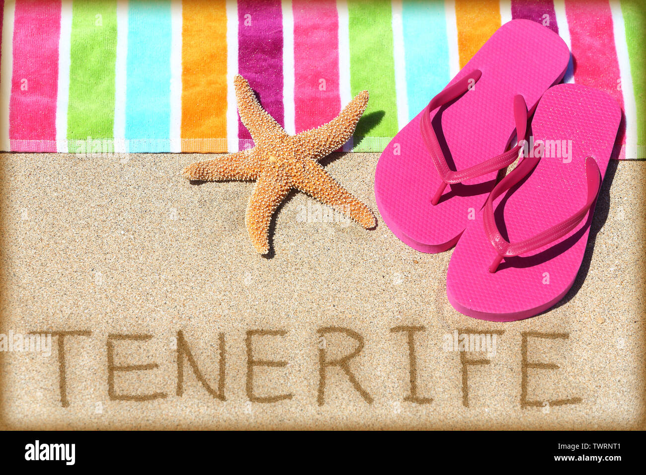 Teneriffa Strand travel concept Hintergrund. Teneriffa in Sand geschrieben mit Wasser neben Strandtuch, Sommer Sandalen und Seesterne. Sommer und Sonne urlaub Urlaub auf den Kanarischen Inseln, Spanien. Stockfoto