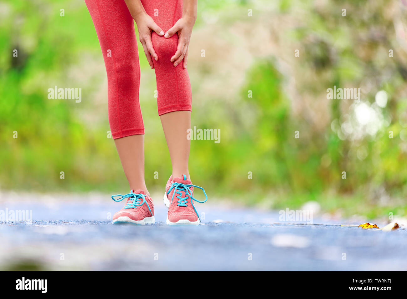 Knieverletzung - Sport laufen Knieverletzungen auf Frau. Läuferin mit Schmerzen von Verstauchung Knie. In der Nähe der Beine, Muskel- und Knie draußen im Wald. Stockfoto