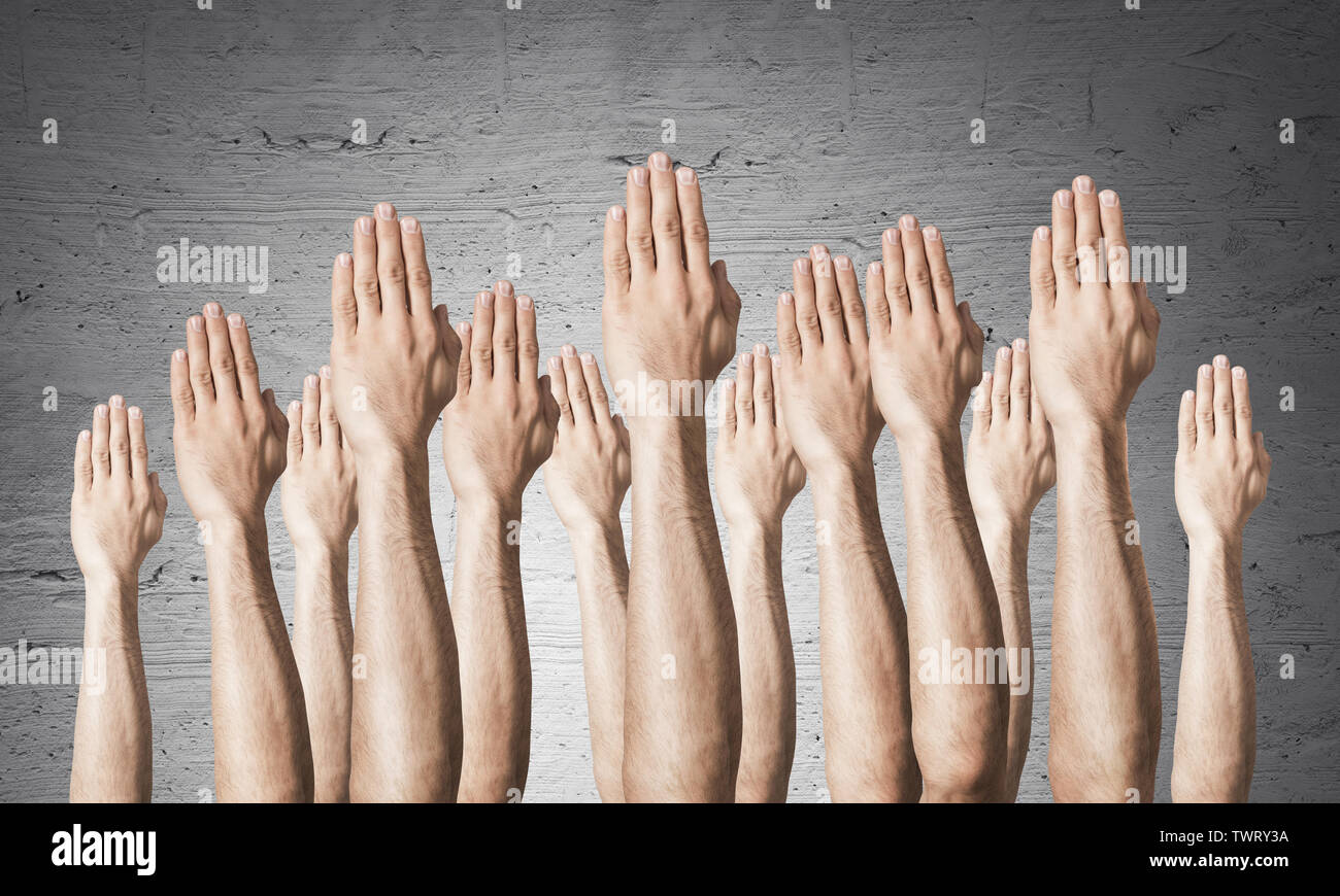 Zeile des Menschen Hände sichtbar Abstimmung Geste. Die Teilnahme und die Vereinbarung Gruppe von Zeichen. Menschliche Hände gestikulierend auf den Hintergrund der graue Wand. Viele Arme heben Stockfoto