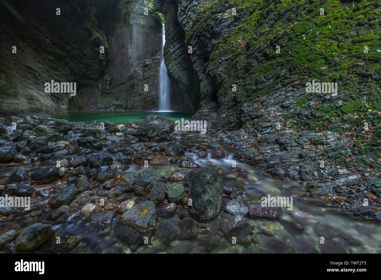 Kozjak Wasserfall in einer Höhle von bemoosten Felsen umgeben, mit Emerald Pool und Creek. Lange Exposition der weltberühmten Touristenattraktion Kozjak, Slowenien. Stockfoto