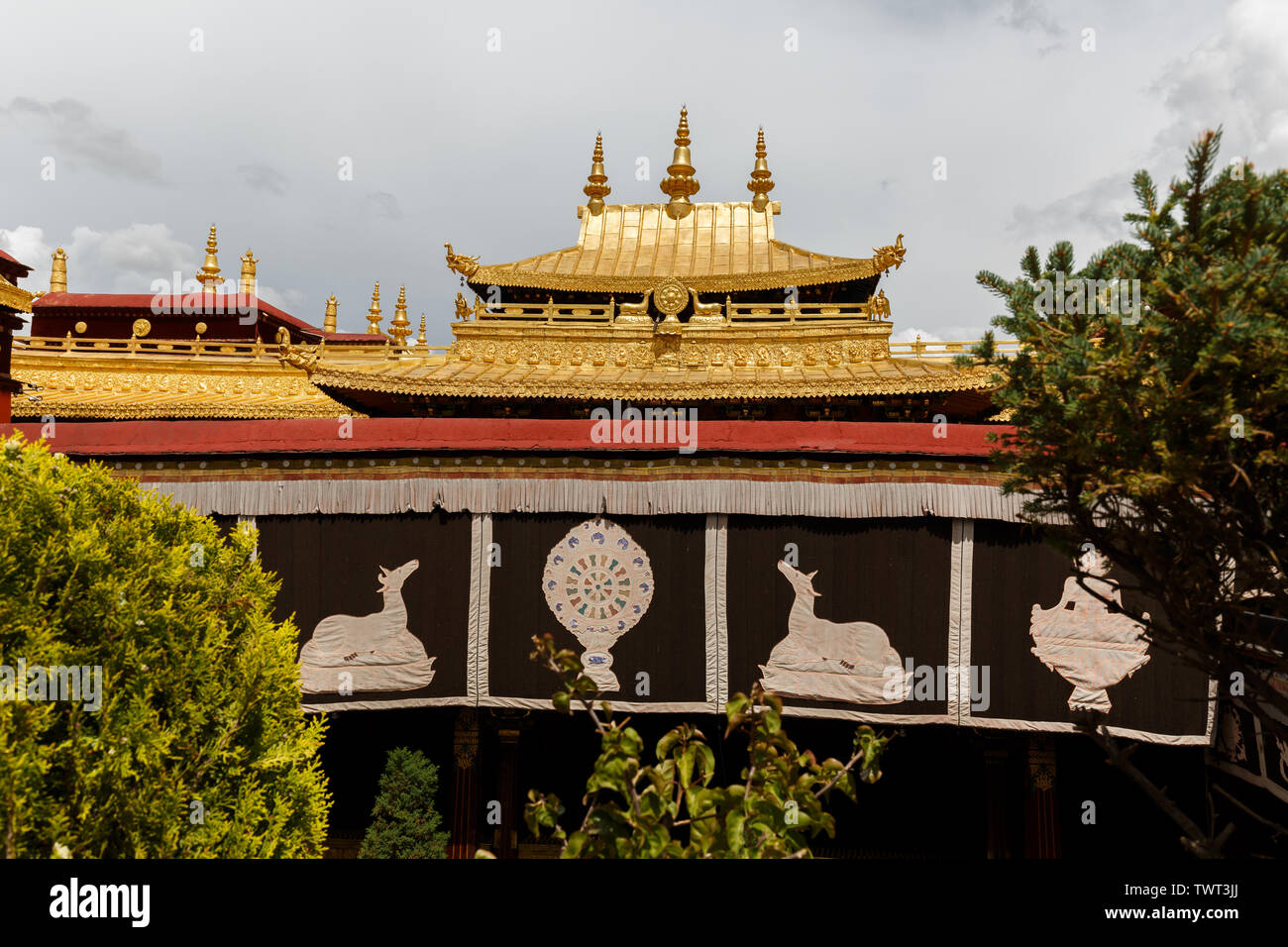 Blick auf die Golden farbiges Dach des Jokhang Tempel. Die berühmten dharma Rad mit Hirsche kann auf dem Dach und auf den Banner in der vorderen gesehen werden. Stockfoto