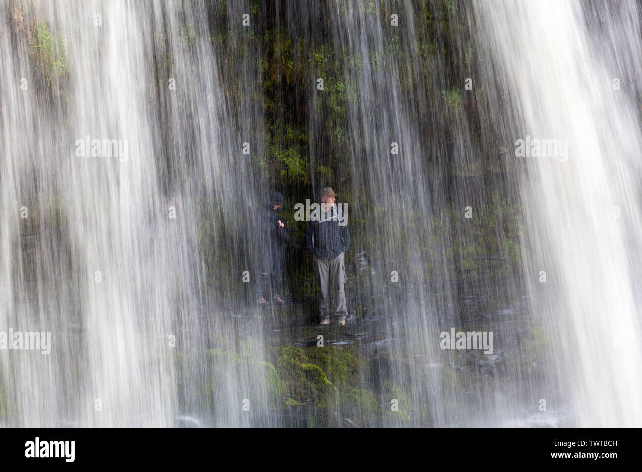 Zu bestimmten Zeiten ist es möglich, hinter Sgwd yr Eira Wasserfall auf die Wasserfälle zu gehen zu Fuß in die Brecon Beacons National Park, Powys, Wales, Großbritannien Stockfoto