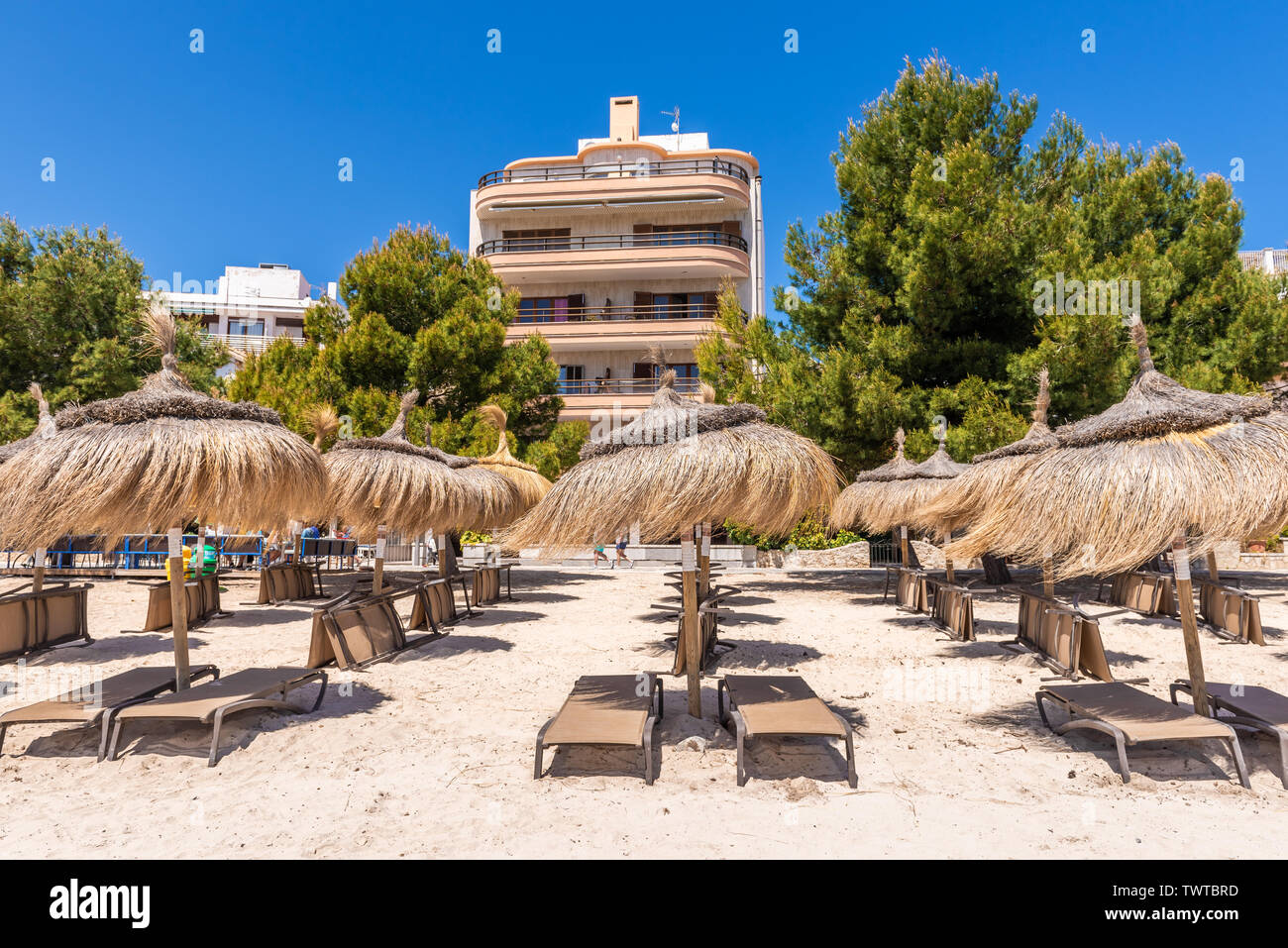 MALLORCA, SPANIEN - 6. Mai 2019: Stroh Sonnenschirme am Strand in Port de Pollenca (Puerto Pollensa), einem beliebten Family Resort im nord-westlich von mallor Stockfoto