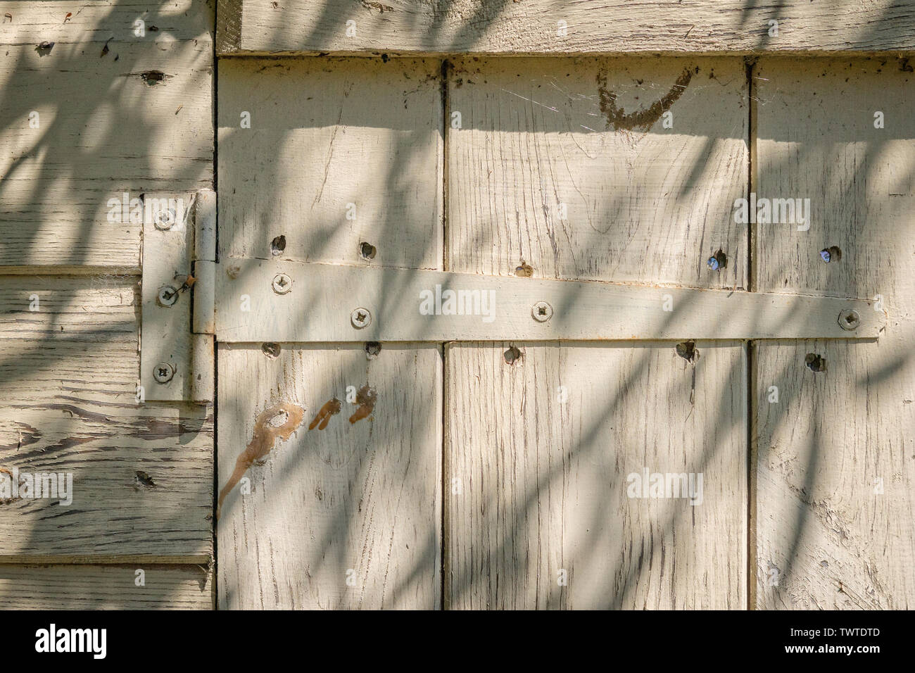 Scharnier gebleicht und gefärbt Holz- gerätehaus Tür. Stockfoto