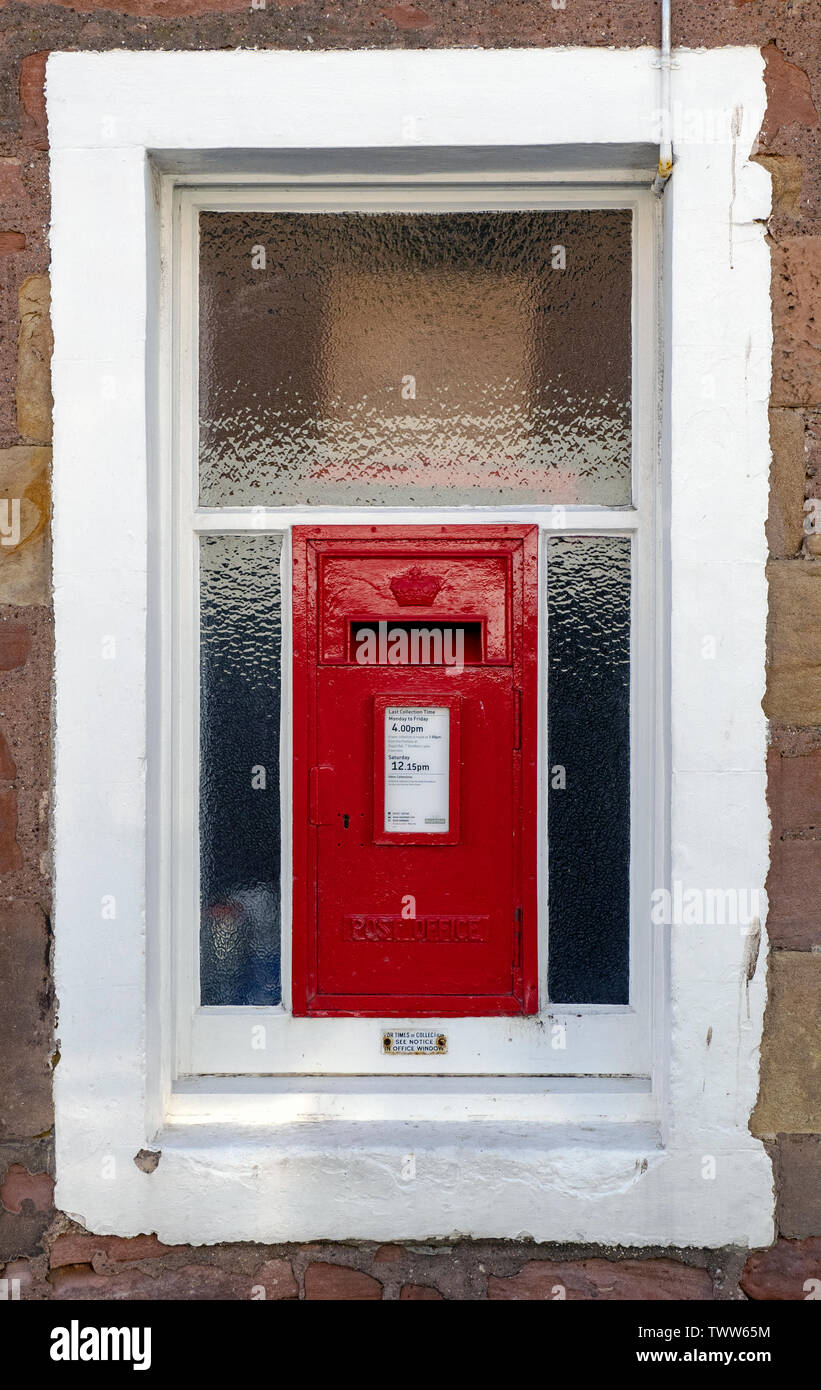 Einen roten Briefkasten in einem Fenster mit einem weißen Rand im Cromarty, Black Isle, Ross und Cromarty, Schottland, Vereinigtes Königreich. Stockfoto