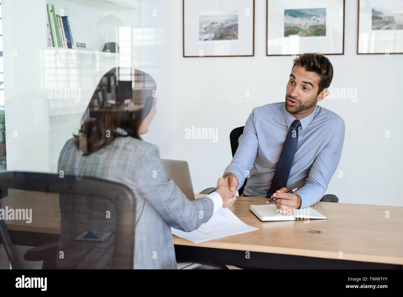 Manager die Hände schütteln mit einem Mitarbeiter in seinem Büro Schreibtisch Stockfoto