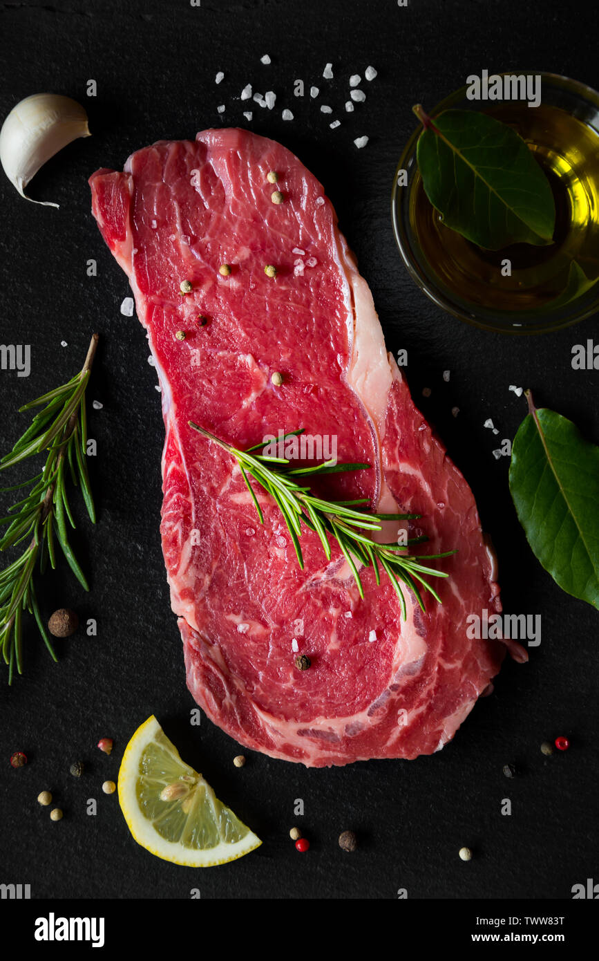 Raw reef Fleisch, rohe Steak mit Rosmarin, Zitrone und Gewürze, bereit zu kochen Stockfoto