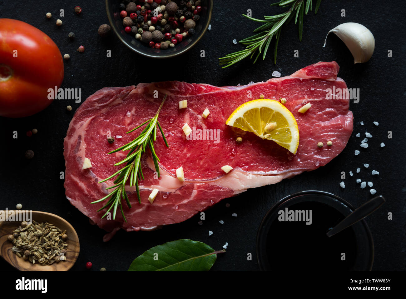 Raw reef Fleisch, rohe Steak mit Rosmarin, Zitrone und Gewürze, bereit zu kochen Stockfoto