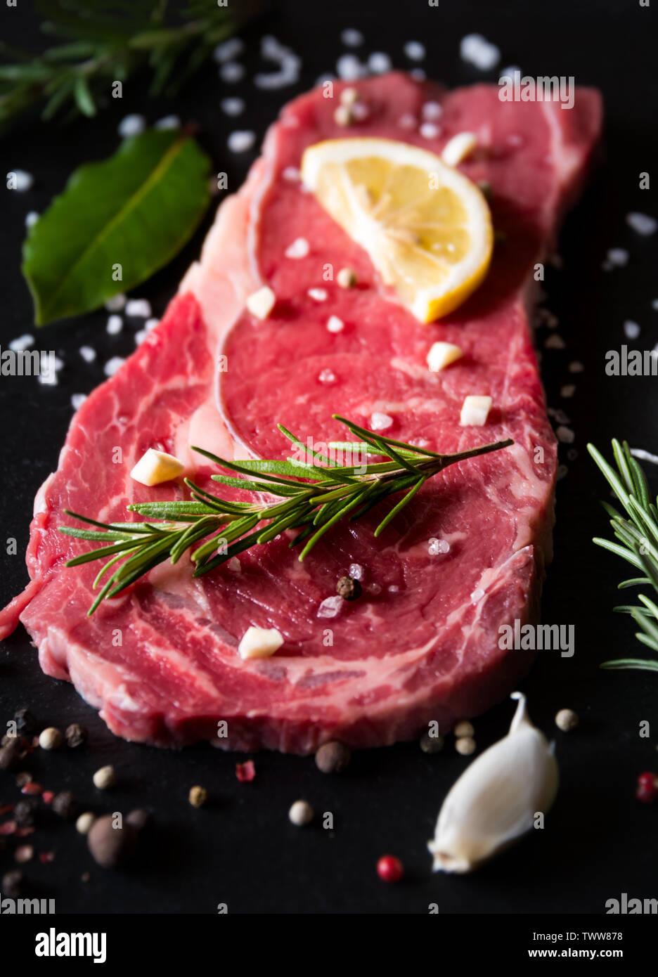 Raw reef Fleisch, rohe Steak mit Rosmarin, Zitrone und Gewürze, bereit zu kochen Stockfoto