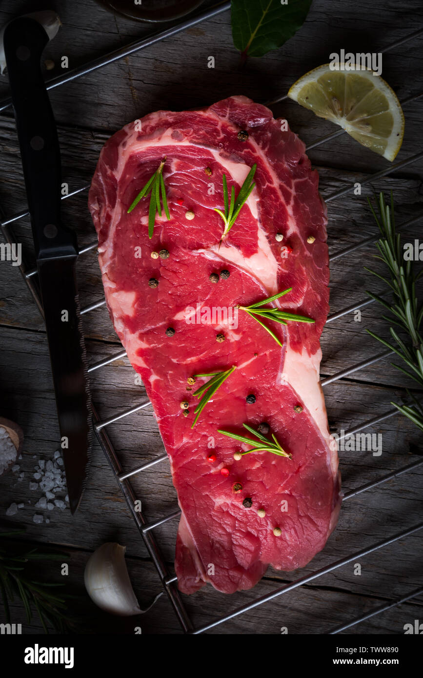 Raw reef Fleisch, rohe Steak mit Rosmarin, Zitrone und Gewürze, bereit zu kochen Stockfoto