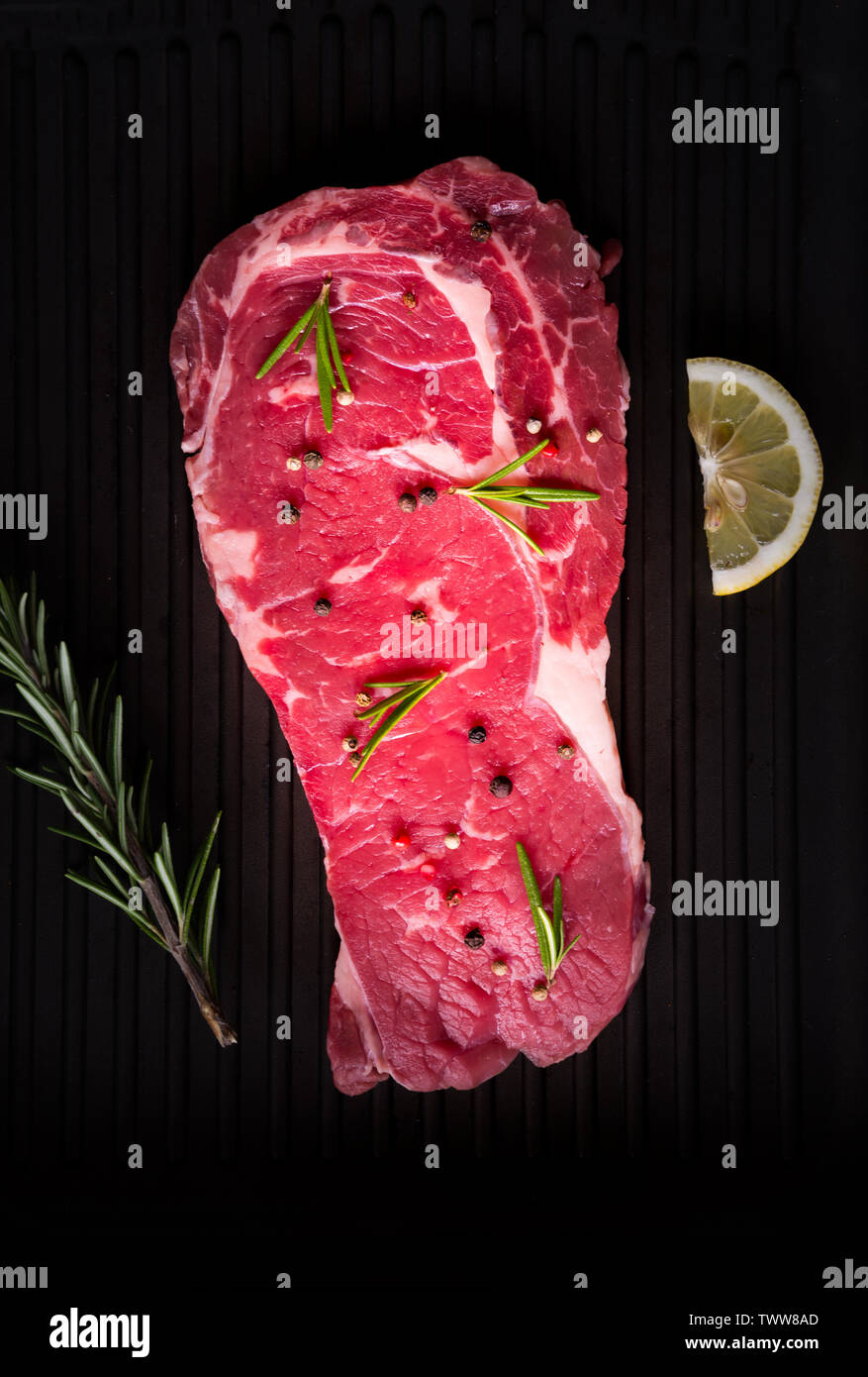 Raw reef Fleisch, rohe Steak mit Rosmarin, Zitrone und Gewürze, bereit zu kochen Stockfoto
