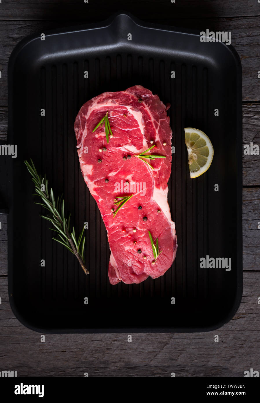 Raw reef Fleisch, rohe Steak mit Rosmarin, Zitrone und Gewürze, bereit zu kochen Stockfoto
