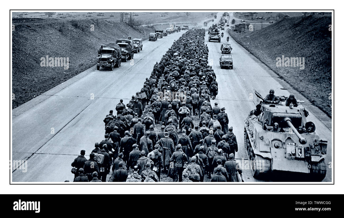 WW2 Massengruppe von Kriegsgefangenen der deutschen Nazi-Armee auf der deutschen Autobahn 04. Mai 1945, Deutschland Tausende deutsche Gefangene marschieren auf einer modernen deutschen Autobahn entlang, während die amerikanischen Streitkräfte mit Panzern, Lastwagen und Jeeps vorwärts drängen. 4.Mai 1945. Stockfoto