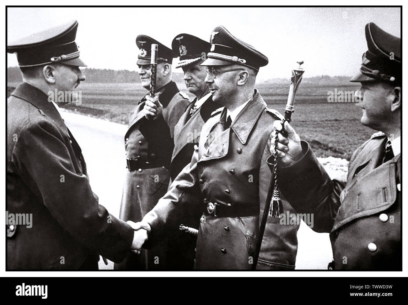 Vintage WW2-Bild von Adolf Hitler die Hände schütteln mit dem deutschen Innenminister und Chef der SS, Heinrich Himmler, mit Grand Admiral Doenitz salutierte mit seinem naval Personal Büro- und Feldmarschall Keitel hinter dem Zweiten Weltkrieg Welt II. Stockfoto