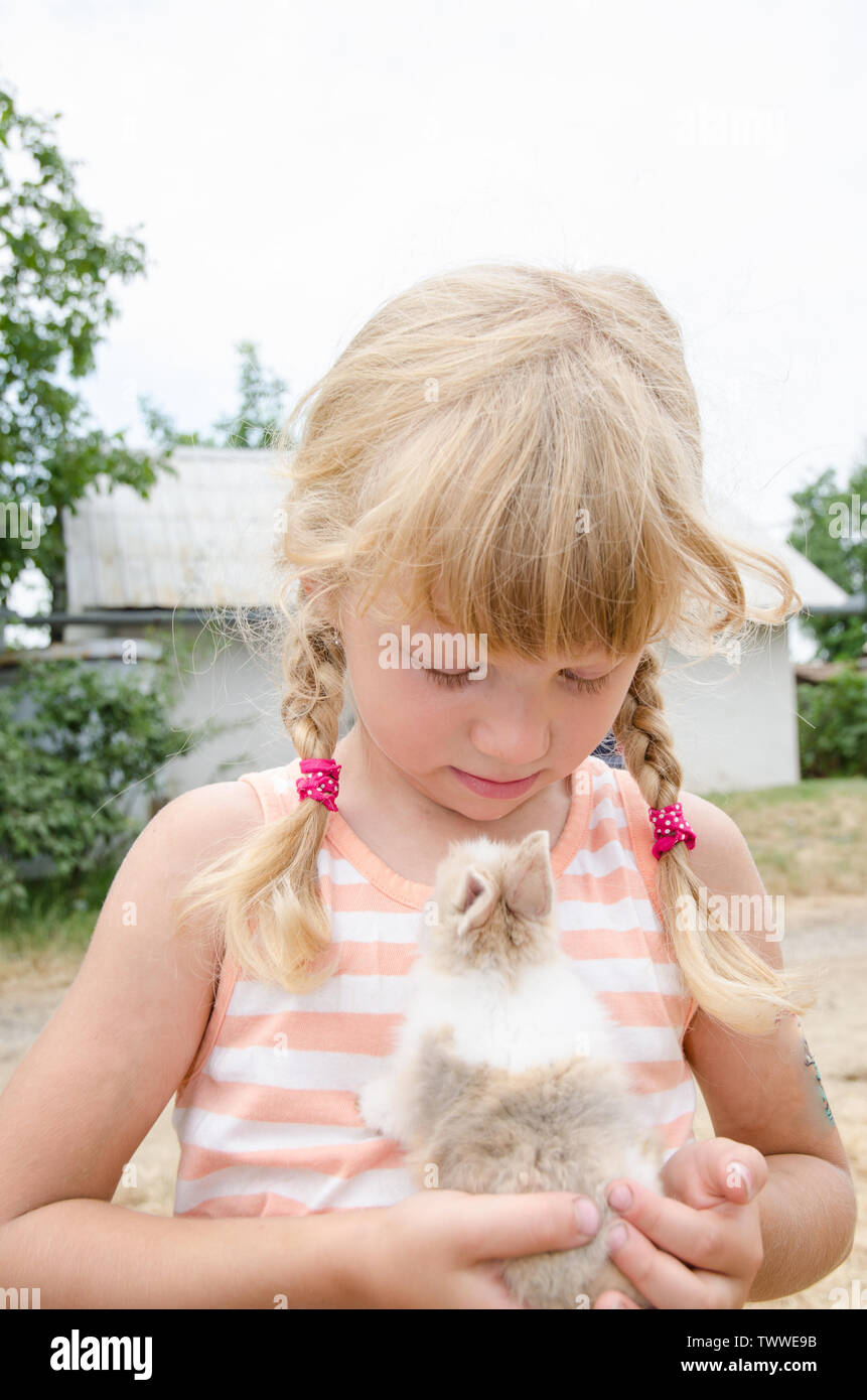 Blonde Mädchen halten kleine Hase Kaninchen Stockfoto