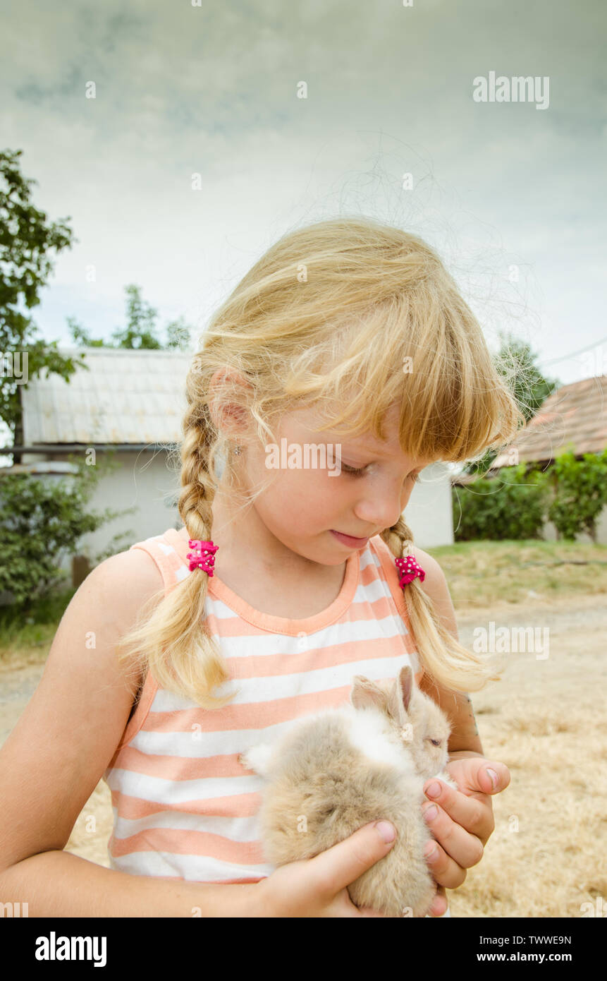 Blonde Mädchen halten kleine Hase Kaninchen Stockfoto