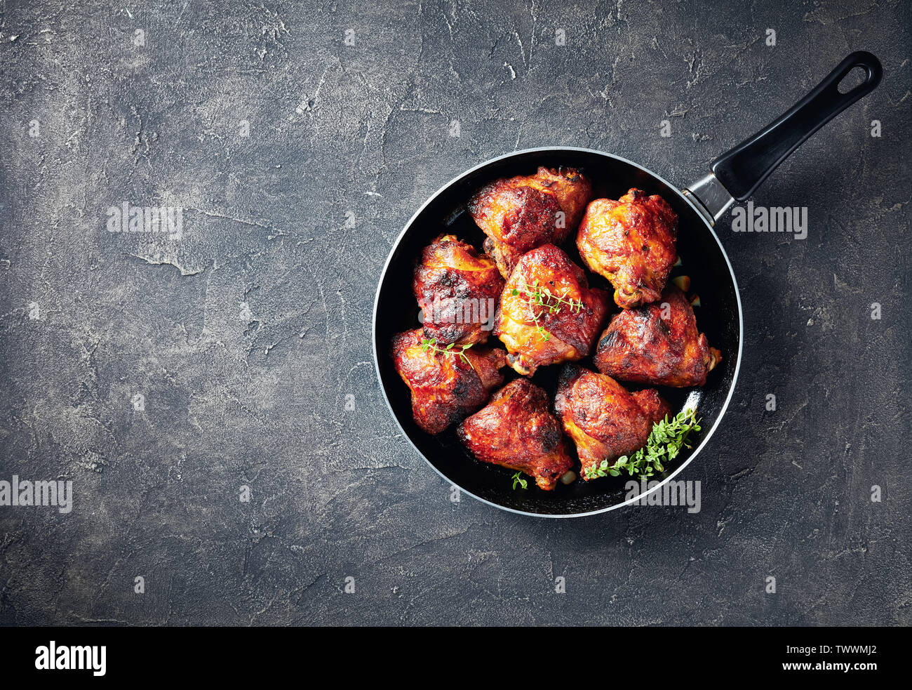 Hot gegrilltes Hähnchen Schenkel in einer Pfanne mit frischem Thymian, Ansicht von oben, flatlay, leeren Raum Stockfoto