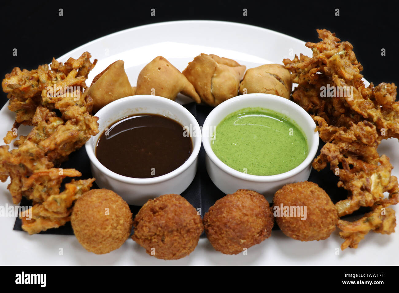 Verschiedene indische Snack pakora Plater mit paneer Kugeln, Zwiebel Chips und Punjabi Samosa Stockfoto