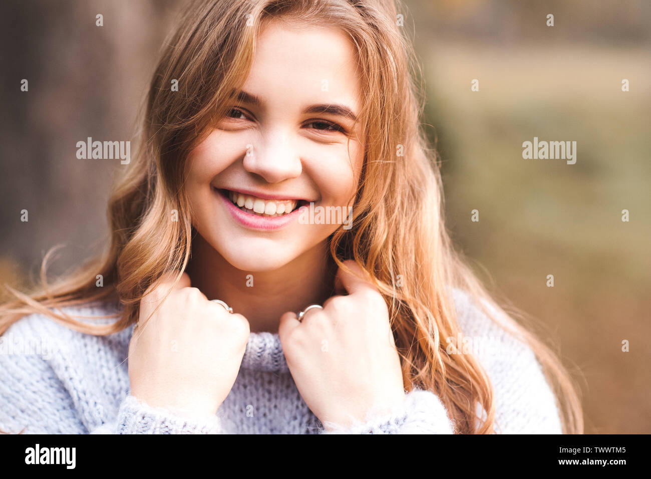 Gerne jugendlich Mädchen 14-16 Jahre alte, gemütliche Strickpullover im Freien. Mit Blick auf die Kamera. Stockfoto