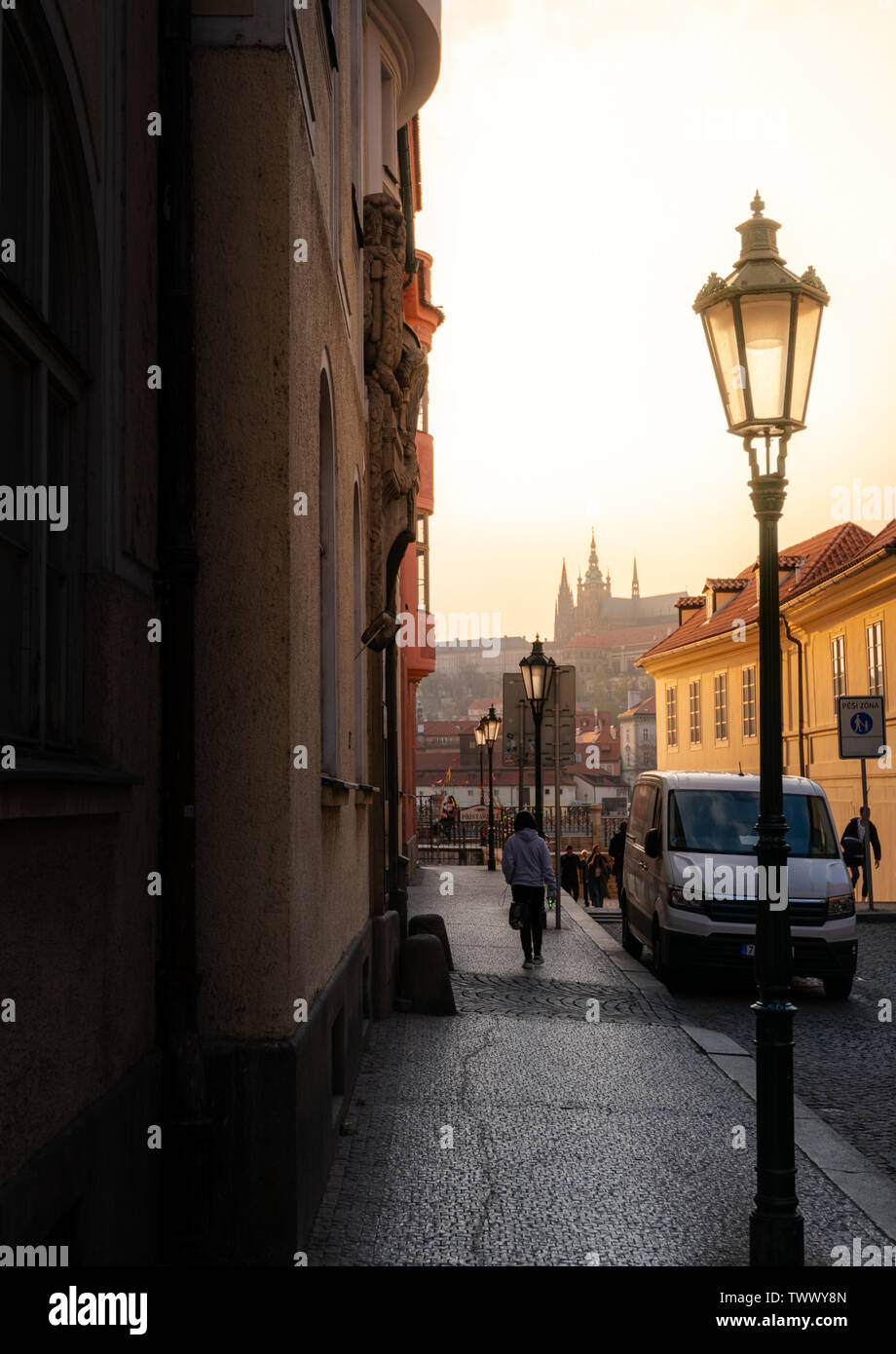 Prag, tschechische Republik - 10 April 2019: der Prager Burg in der Ferne einen klassischen tschechischen Straße bei Sonnenuntergang. Stockfoto