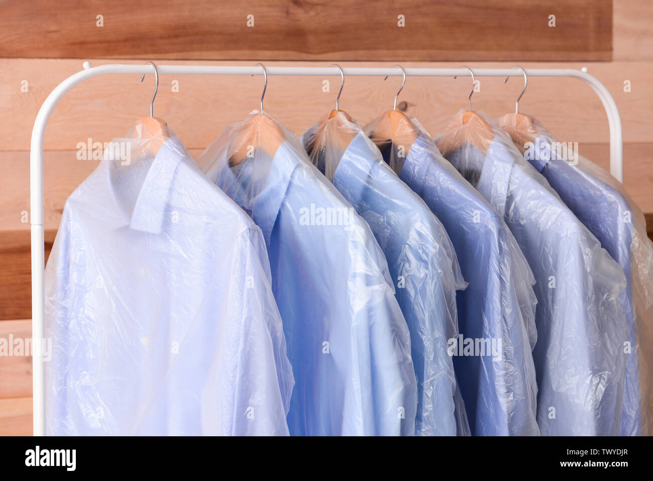 Rack mit Kleidung nach chemische Reinigung auf hölzernen Hintergrund  Stockfotografie - Alamy