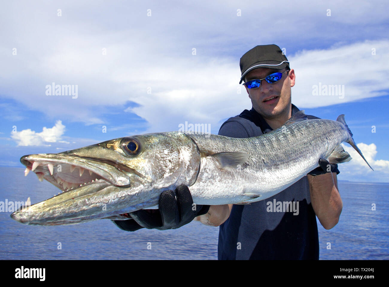 Hochseefischen, Fischfang, big game fishing, Lucky Fisherman Holding eine riesige Barracuda Stockfoto