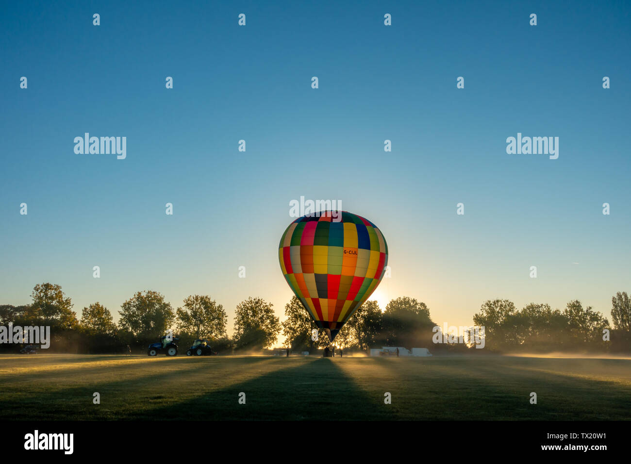Starten einer bunten Heißluftballon auf dem Goodwood Estate in der Nähe von Chichester im Winter. Stockfoto