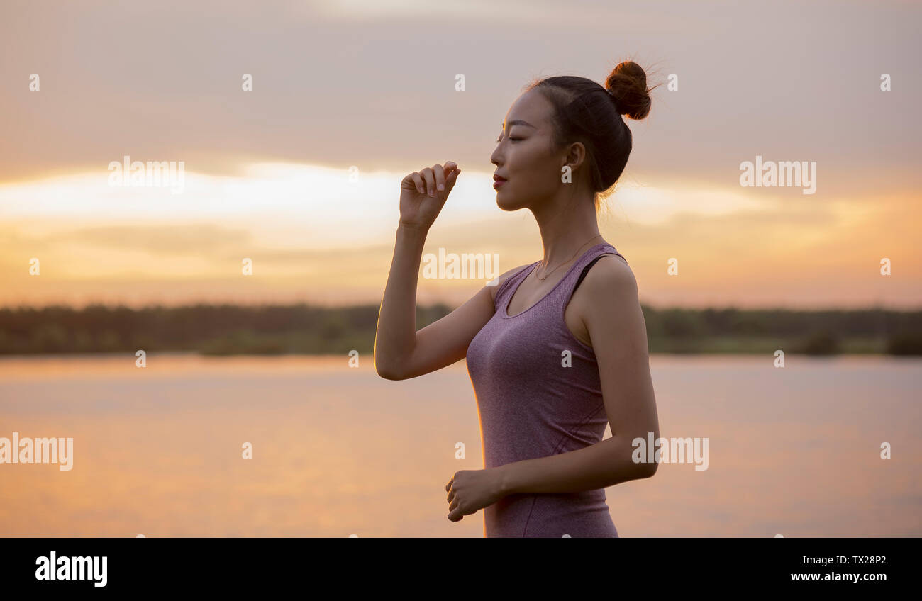 Sonnenuntergang Yoga, Sonne Wasser, Dawn und Sky. Sommer kostenlos Natur Natur Frau im Freien. Freizeitaktivitäten. Komfort Wetter. Keine Sorge. Meditation. Balance Strand. Zeitvertreib. Hintergrundbeleuchtung entspannend Stockfoto