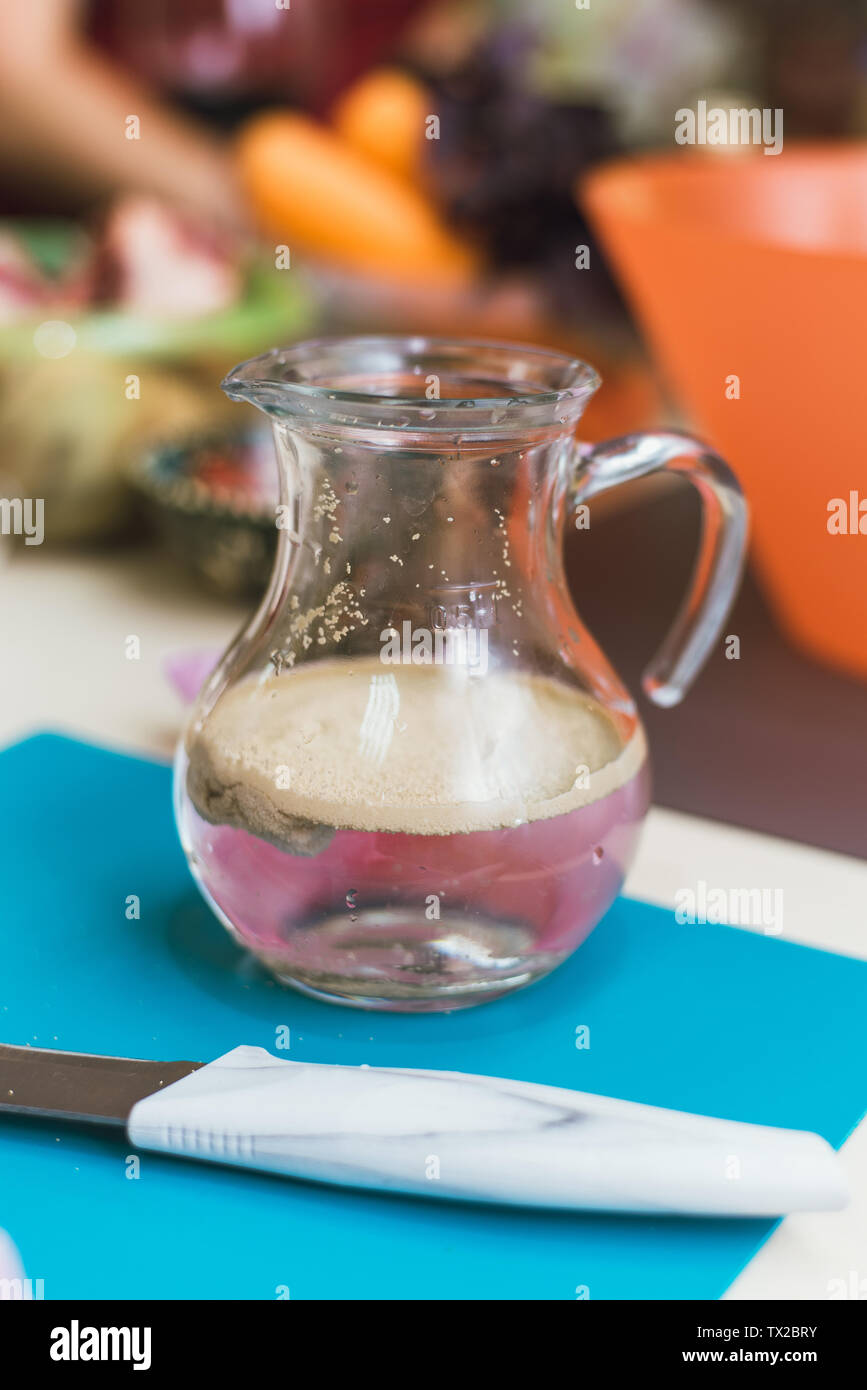 Schraube - Hefe, Zucker und Wasser im Glas. Cook gießt kochendes Wasser über die Hefe die Maische für den Teig zu erhalten. Der Teig wird durch Verdünnung Hefe mit kochendem Wasser Stockfoto