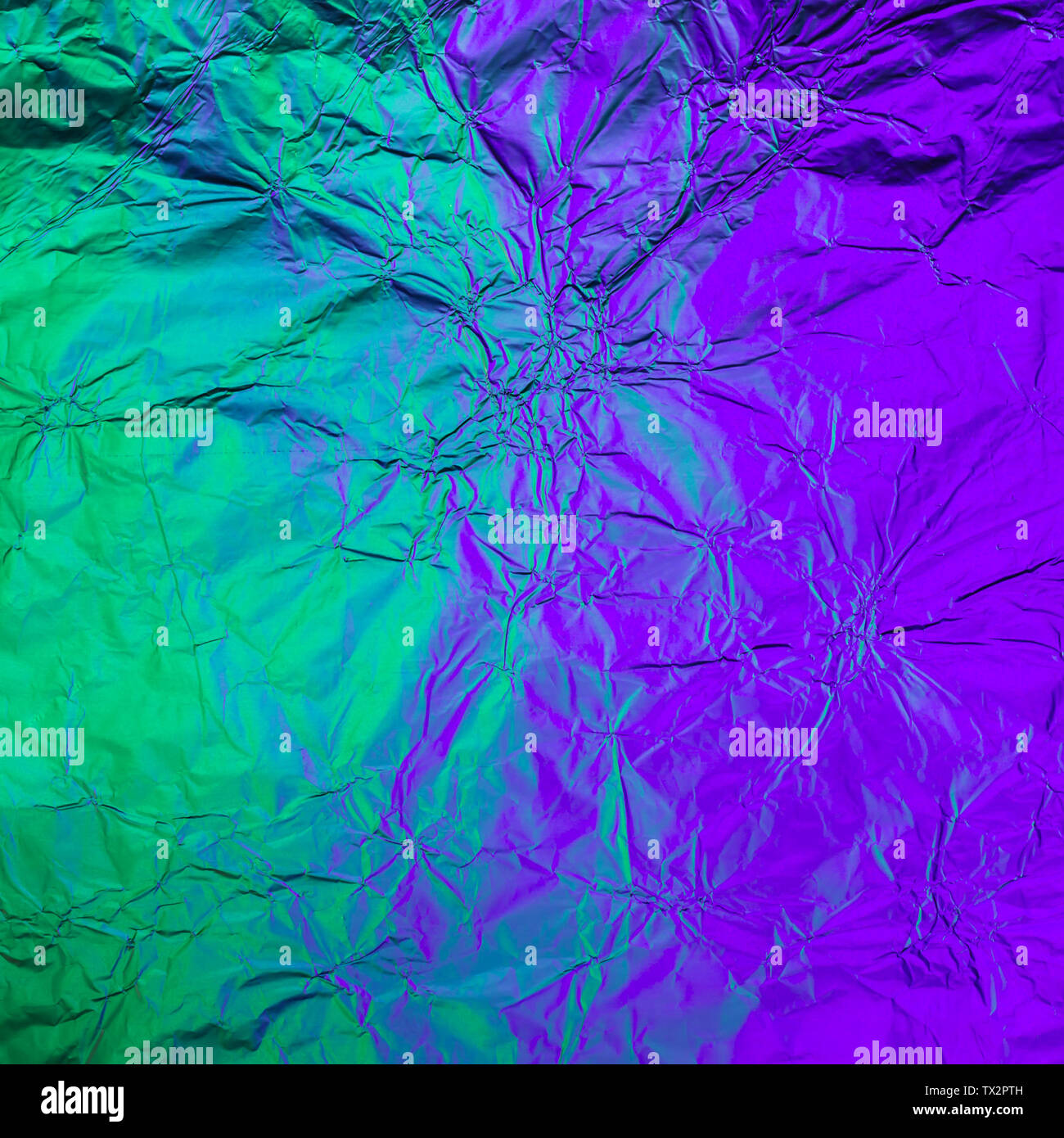 Lila Grün zerknitterte Hintergrund aus beleuchtete Folie. Trendy duplex  Textur Stockfotografie - Alamy