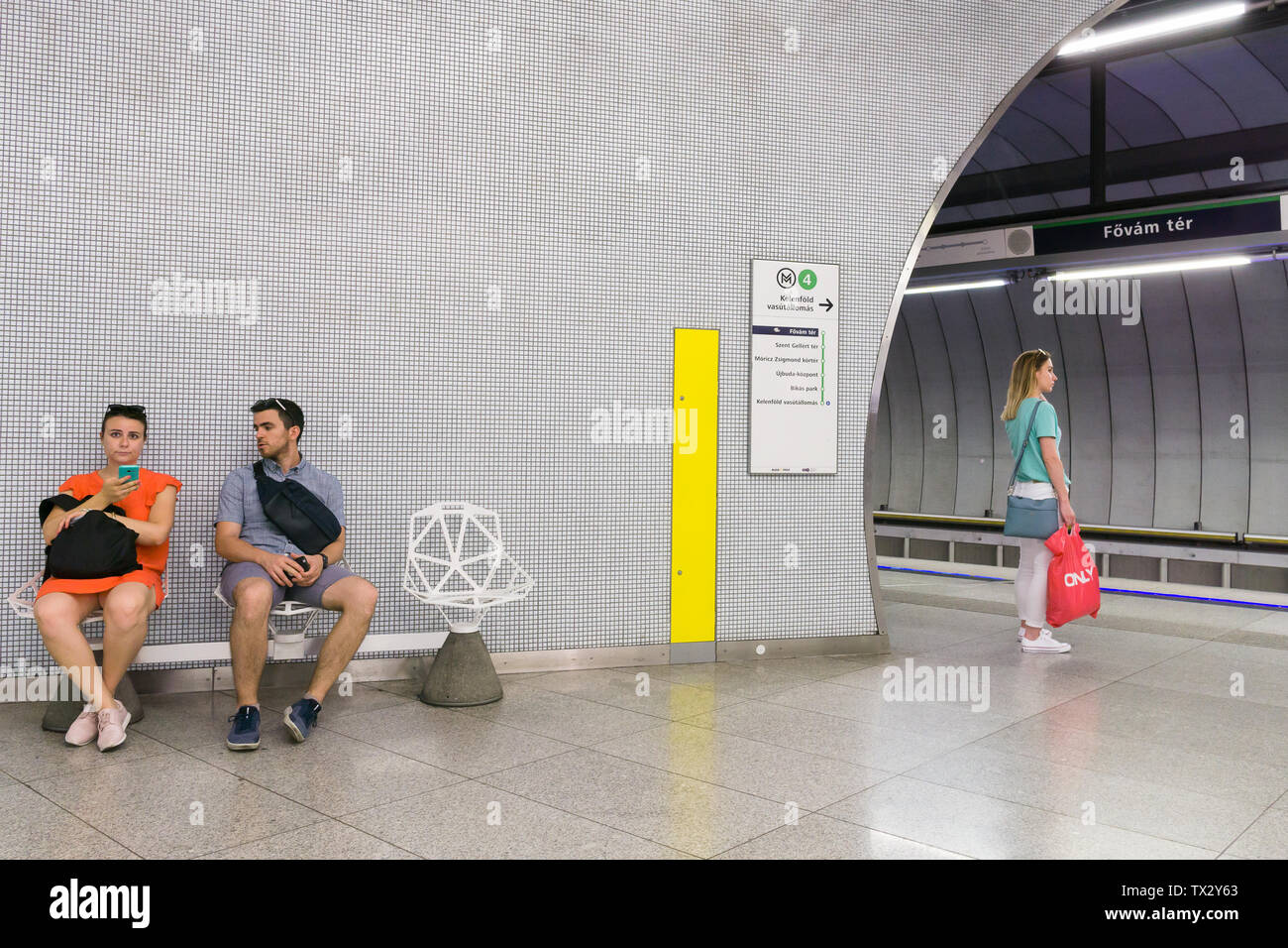 Passagiere für einen Zug an der Fovam Ter Metro Station auf M4 Linie in Budapest, Ungarn warten. Stockfoto