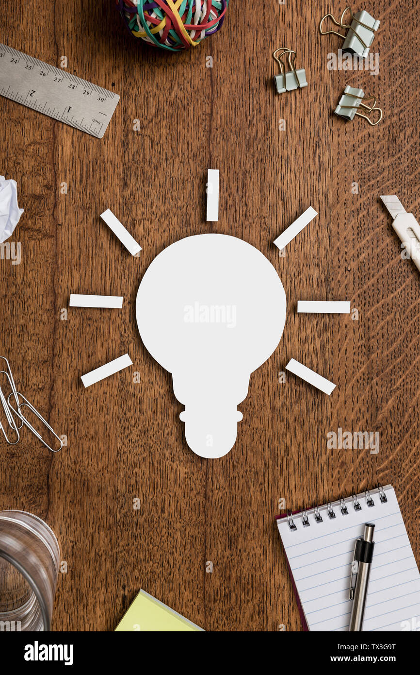 Ansicht von oben Glühbirne und Bürobedarf auf hölzernen Schreibtisch angeordnet - knolling Stockfoto