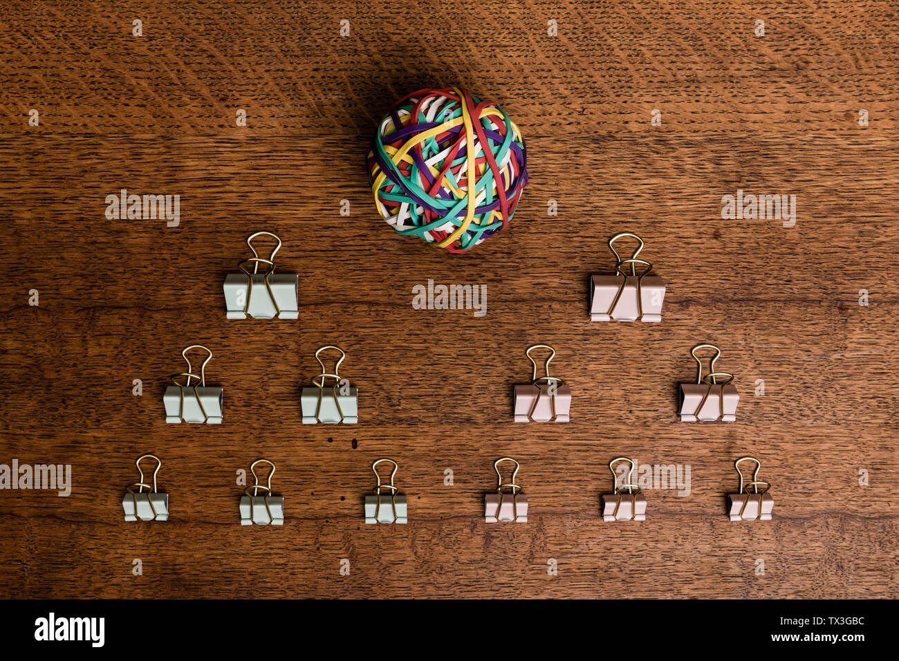 Ansicht von oben binder clips und Gummiband Ball auf hölzernen Schreibtisch - knolling Stockfoto