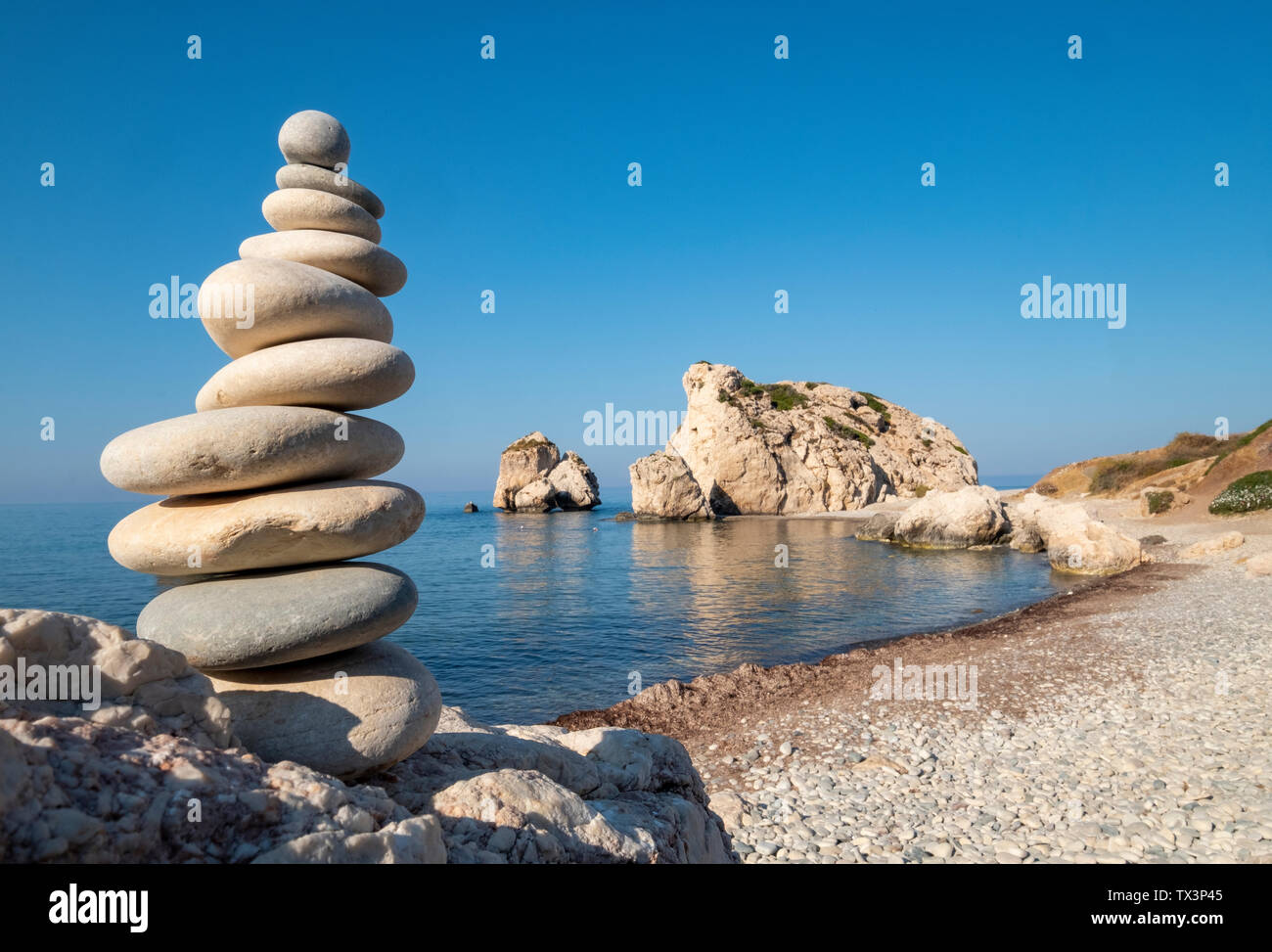 Ein Stein stack vor den Felsen der Aphrodite (Petra Tou Romiou), Paphos Region, Republik Zypern. Stockfoto