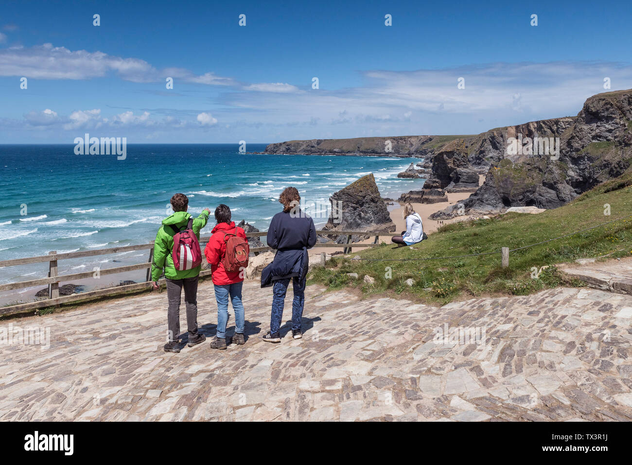 Wanderer auf der Aussichtsplattform den Blick über robuste, spektakuläre Bedruthan Steps auf der nördlichen Küste von Cornwall. Stockfoto