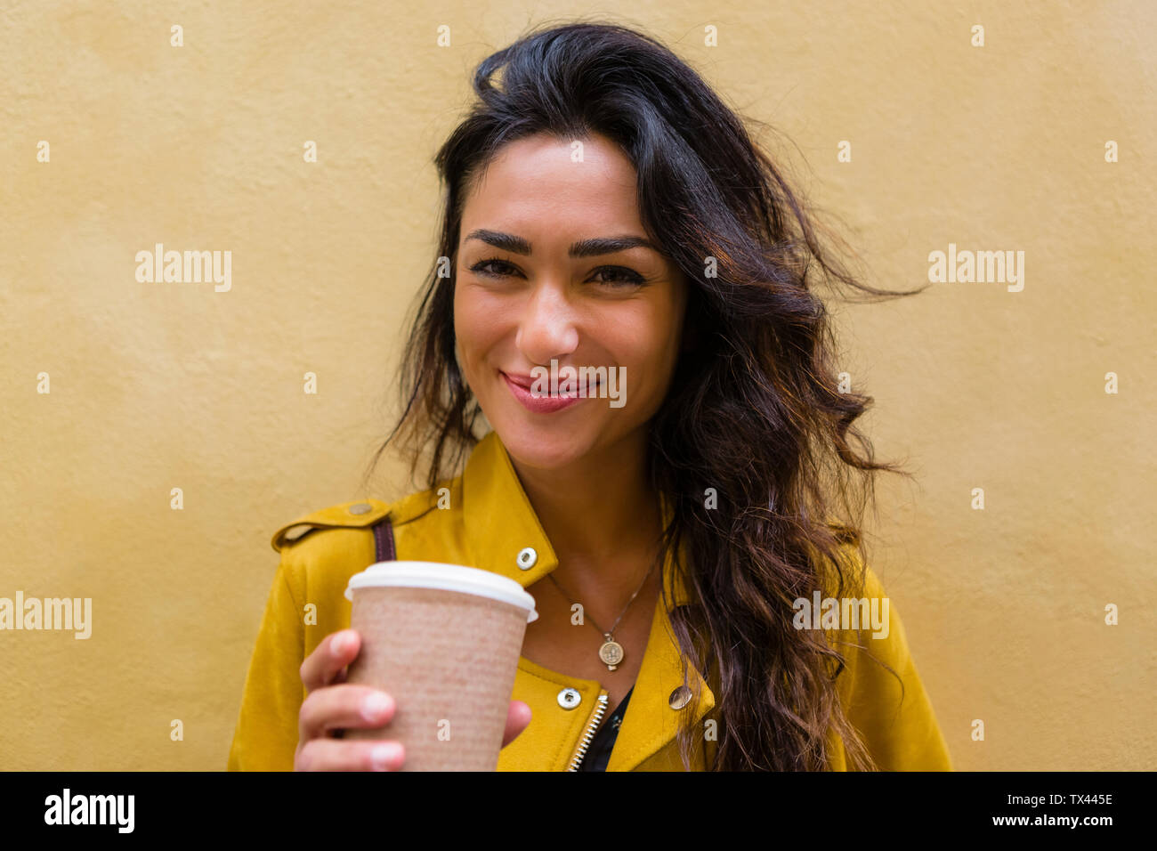 Porträt der jungen Frau tragen gelbe Leder Jacke, Tasse Kaffee Stockfoto