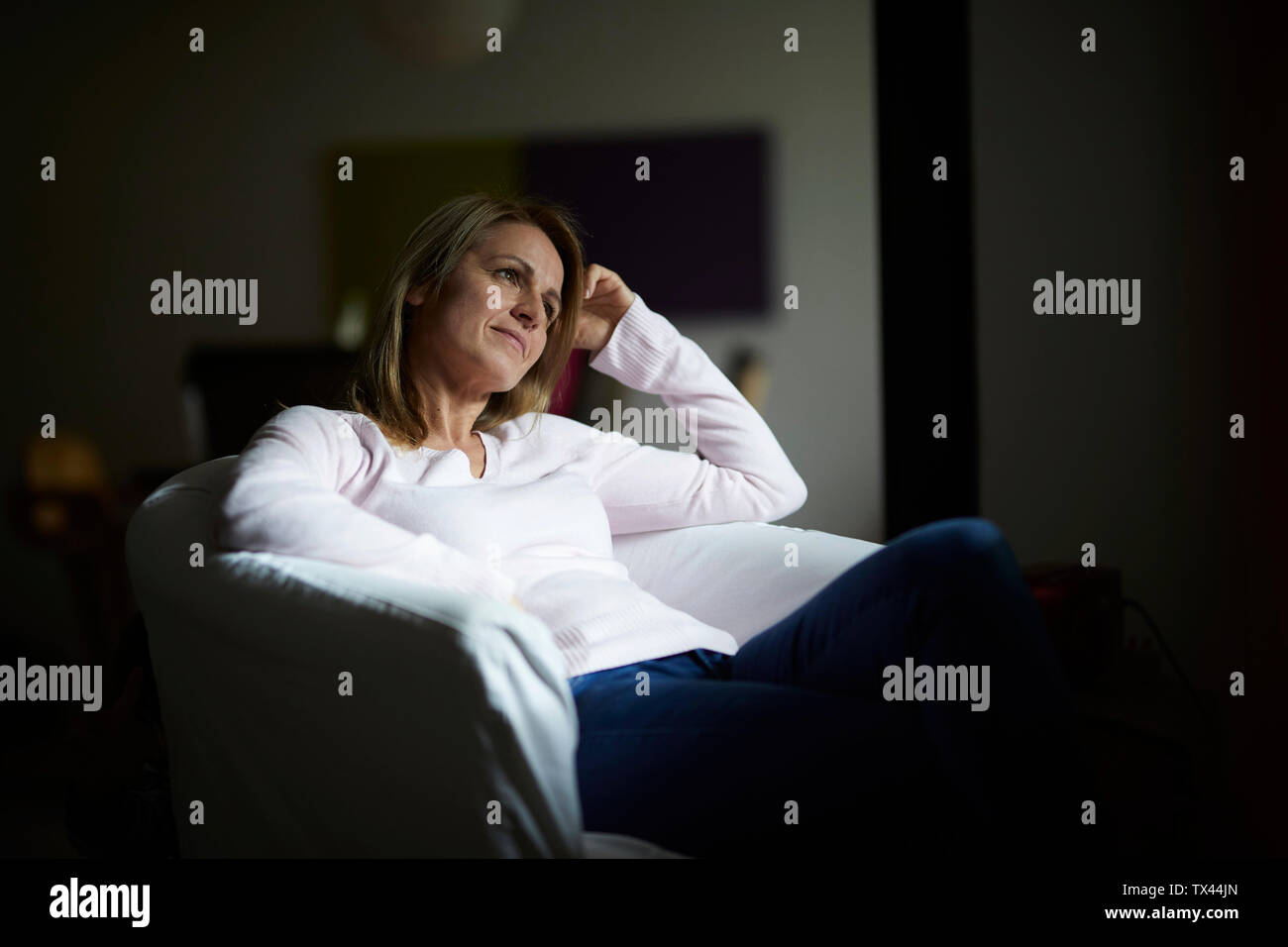 Frau sitzt zu Hause, entspannen Sie im Sessel Stockfoto