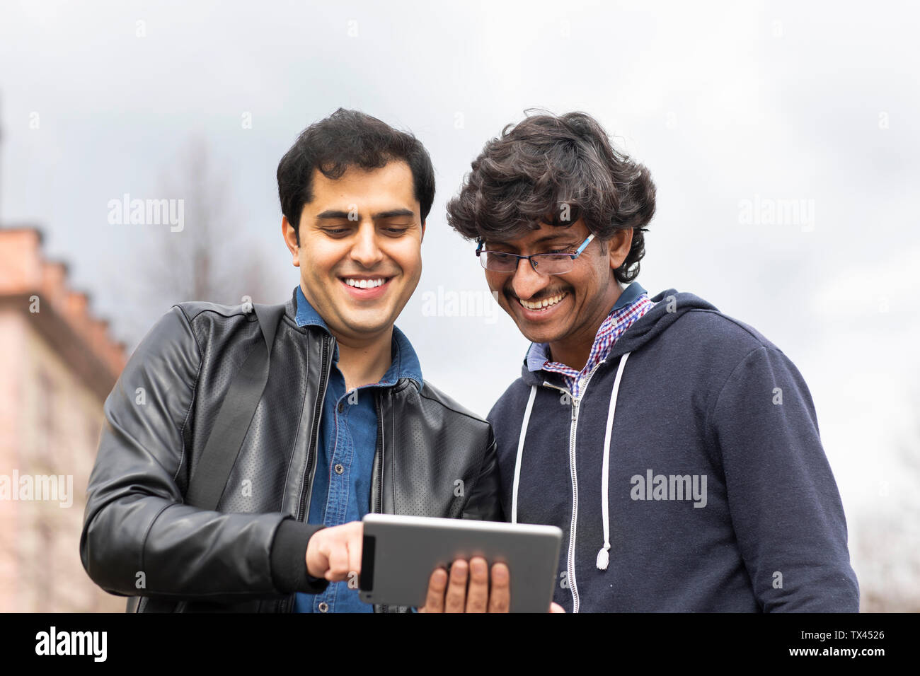 Portrait von lächelnden Freunde mit Mini Tablet im Freien Stockfoto