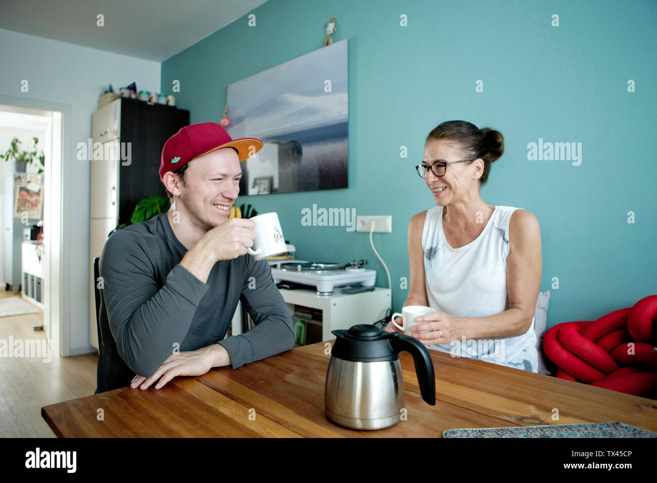 Mutter und Sohn am Küchentisch sitzen, Kaffee trinken Stockfoto