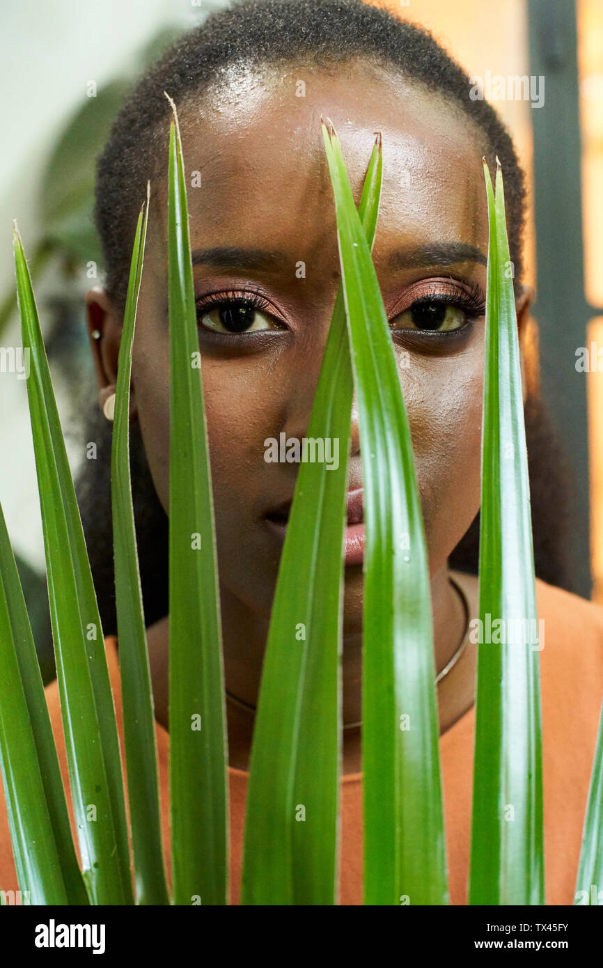 Porträt der jungen Frau hinter einer Anlage Stockfoto
