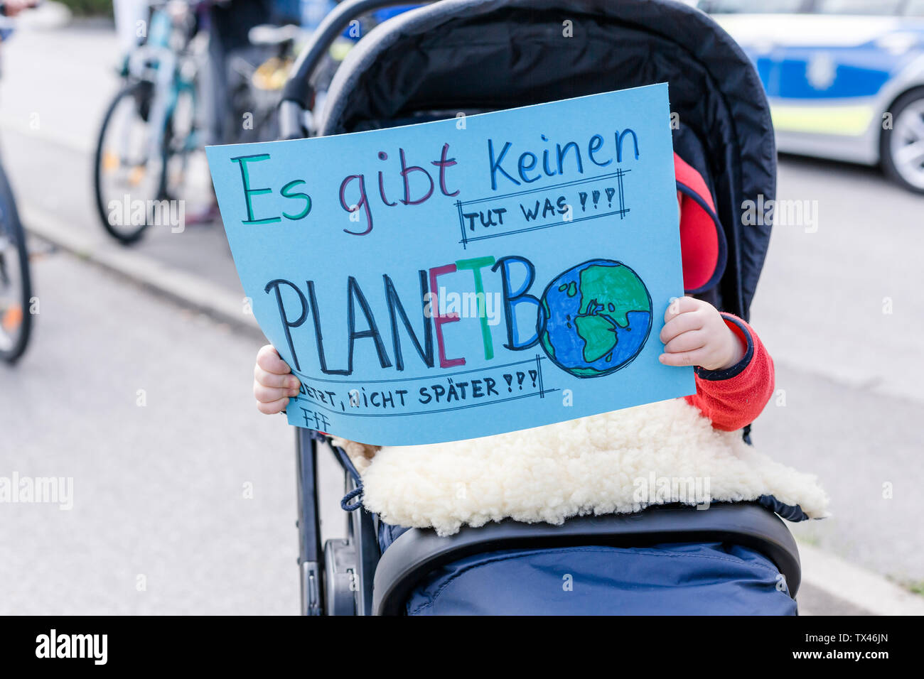 Baby in einem Kinderwagen Holding ein Plakat auf einer Demonstration für den Umweltschutz Stockfoto