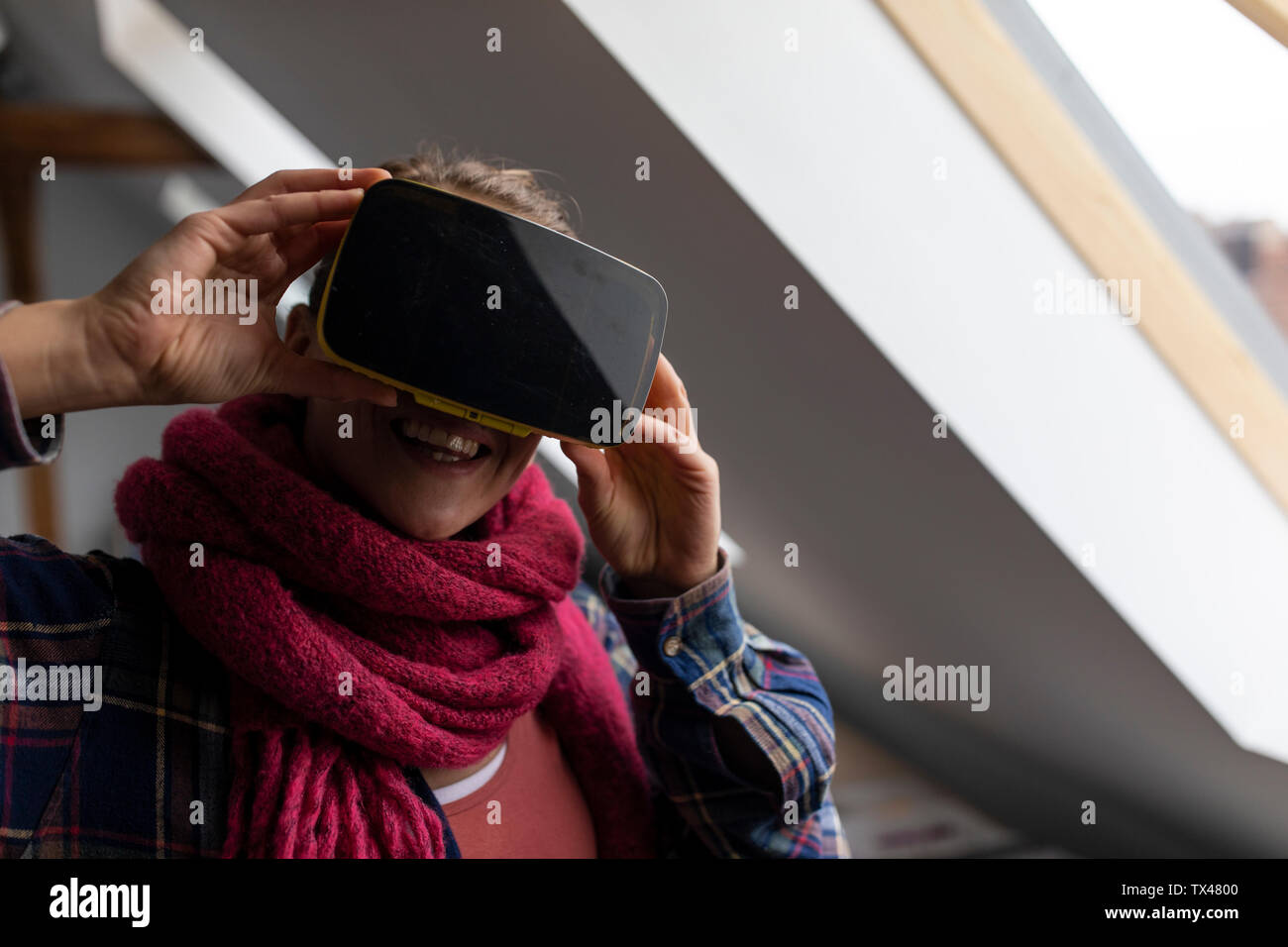 Glückliche junge Frau mit VR-Brille Stockfoto