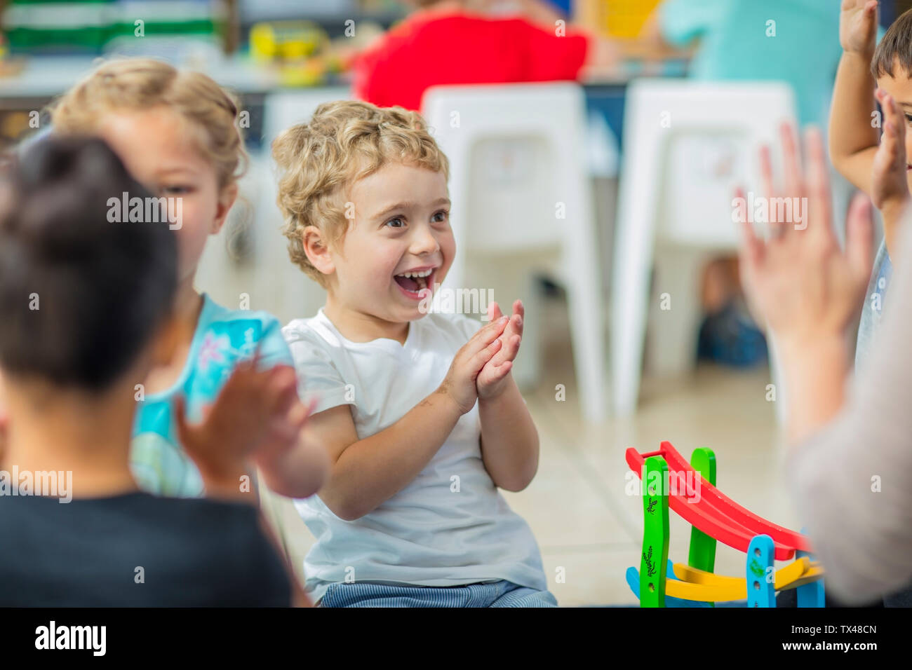 Glückliche Kinder und Pre-school Lehrer Händeklatschen in Kindergarten Stockfoto