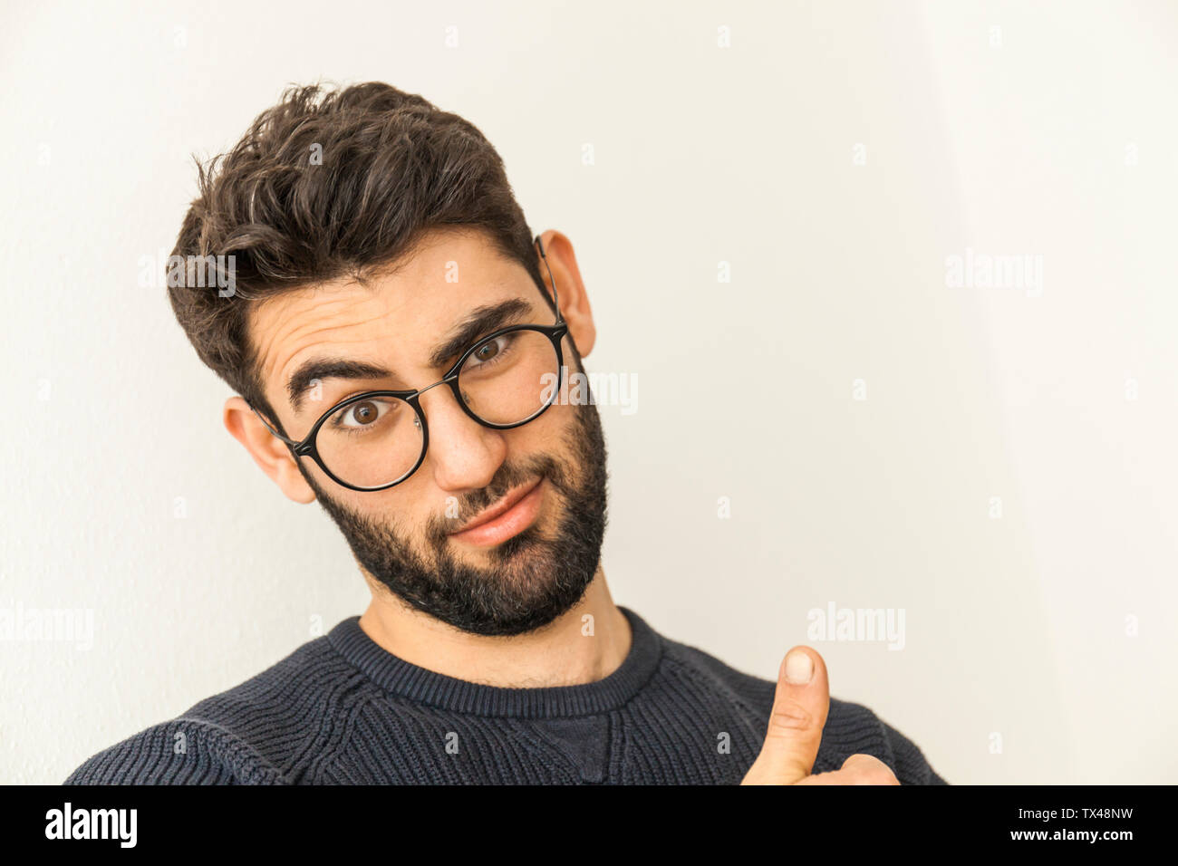 Portrait von Zweifelnden jungen Mann mit Bart und Brille Stockfoto