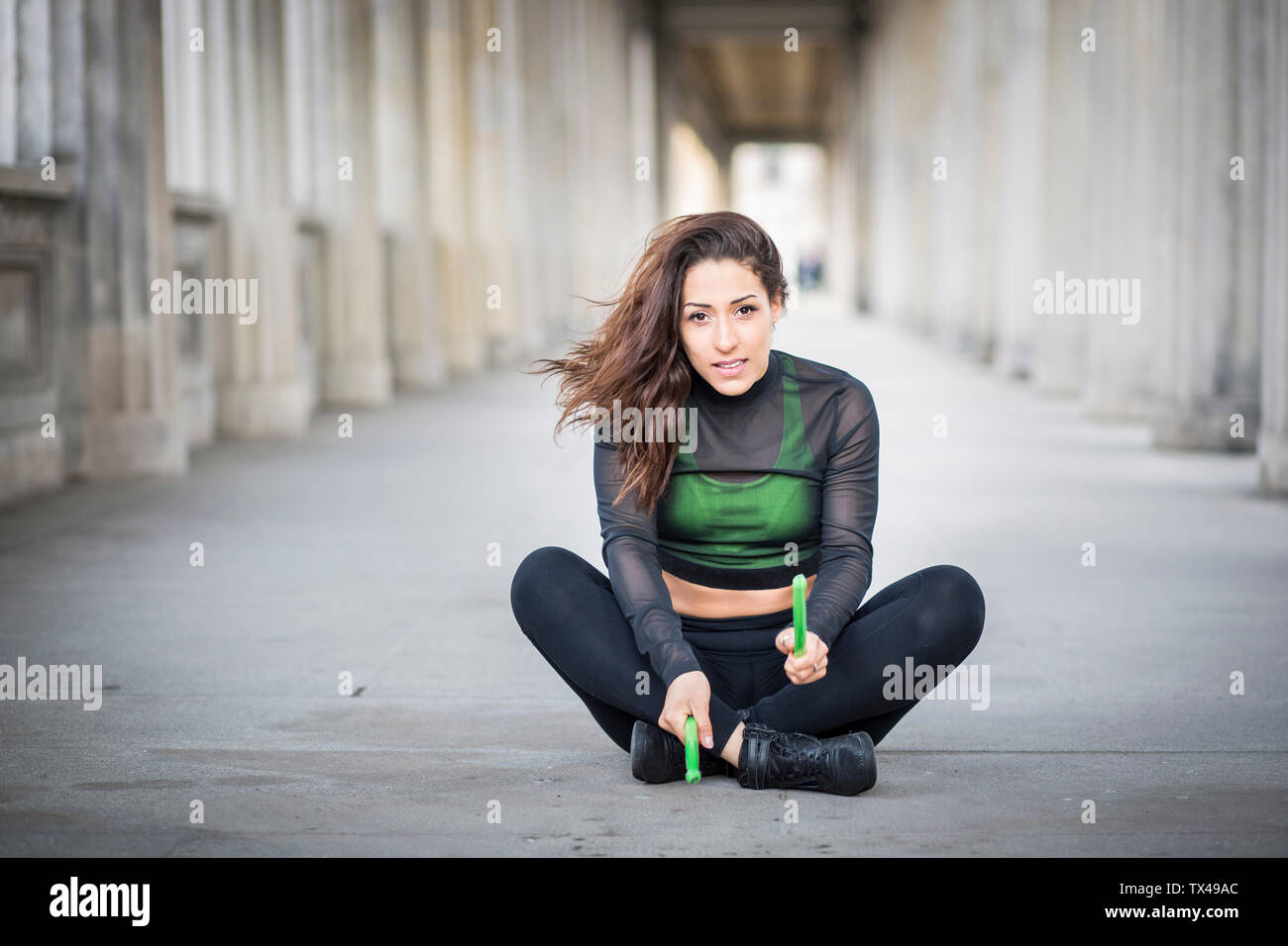 Junge Frau auf dem Boden sitzend, pound Fitness Übung Stockfoto