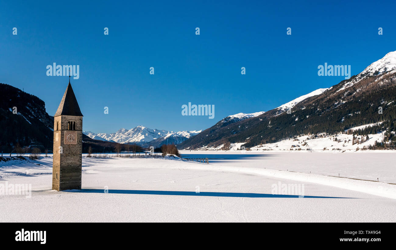 Italien, Vinschgau, versunkene Turm in gefrorenen Lago di Resia im Winter Stockfoto