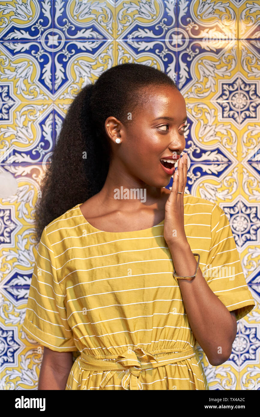 Überrascht junge Frau an einem gefliesten Wand Stockfoto