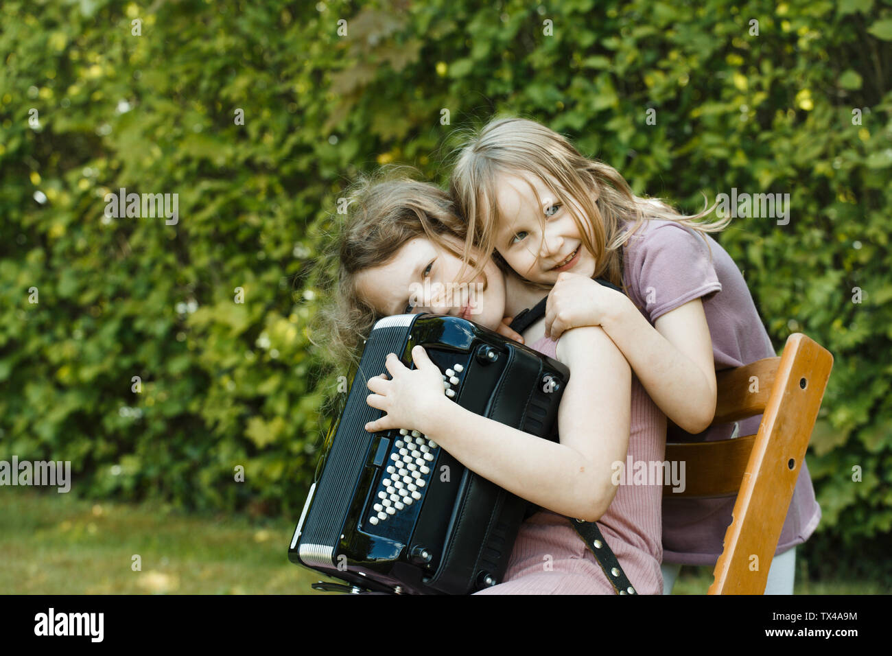 Mädchen mit Akkordeon und ihre Schwester, die Verklebung mit jeder anderen Stockfoto