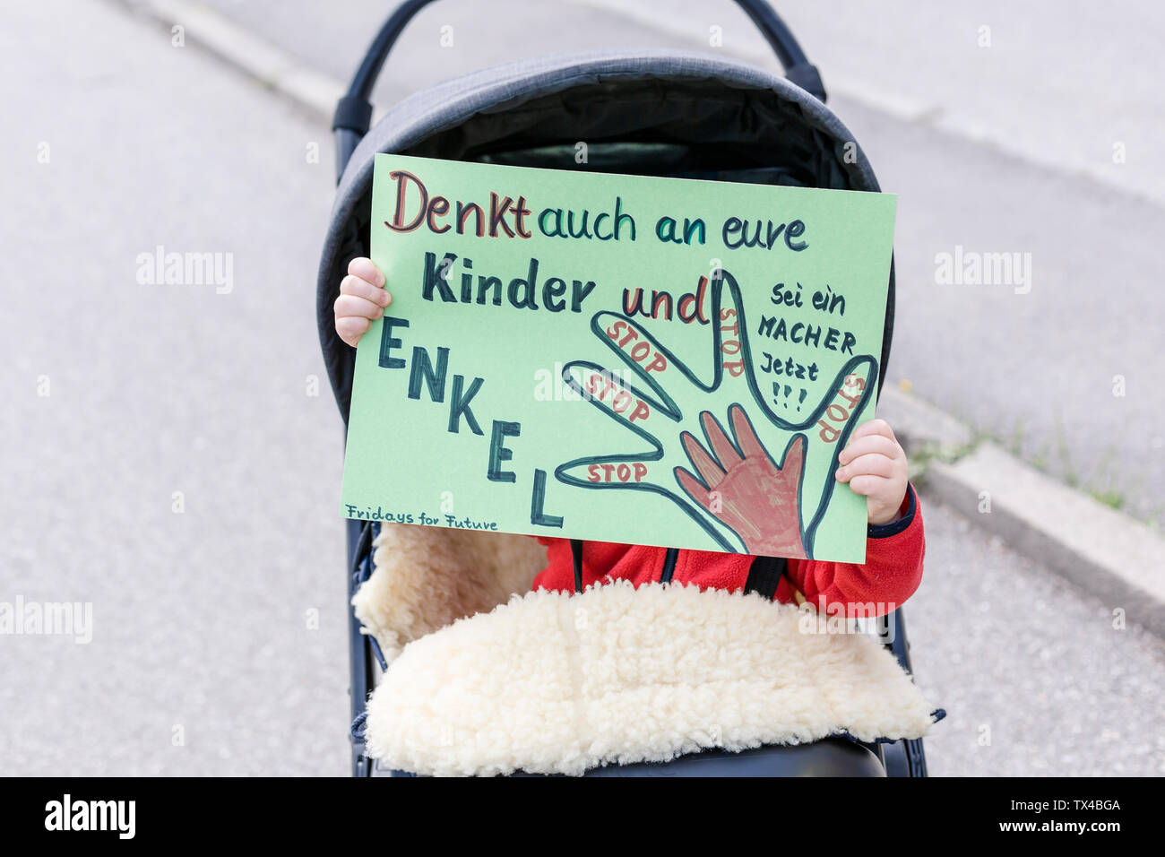 Baby in einem Kinderwagen Holding ein Plakat auf einer Demonstration für den Umweltschutz Stockfoto