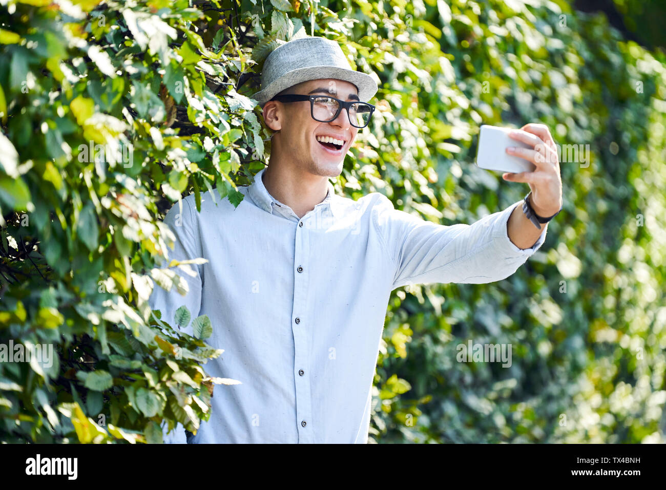 Glückliche junge Menschen nehmen in einer Hecke selfie Stockfoto